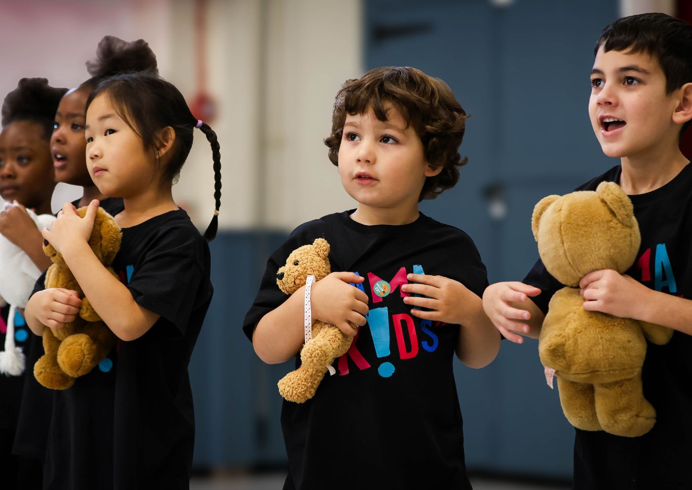 Young Drama Kids students holding teddy bears while taking part in a group drama activity